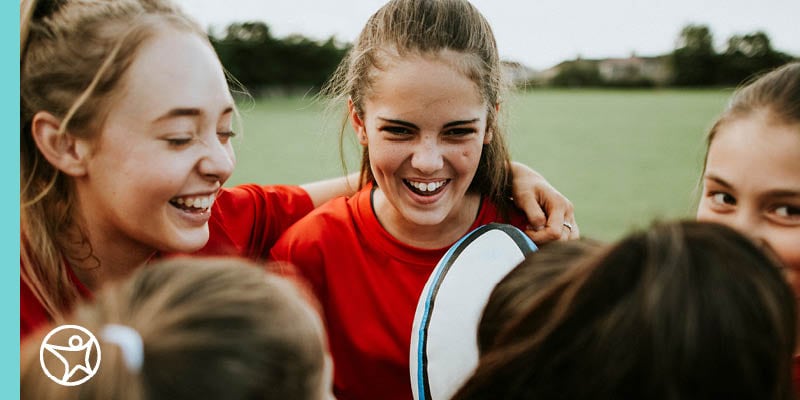 A group of diverse young students gathered together to play a team sport.