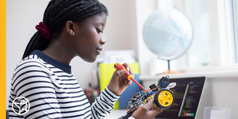 A high school student working on reparing a robot for ar STEM project.