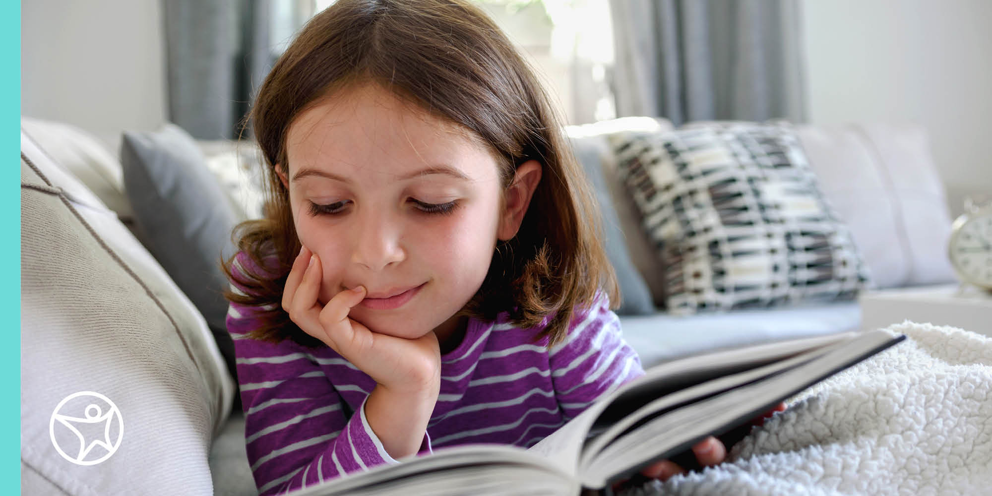 A young student in a purple shirt is reading books during the summer image