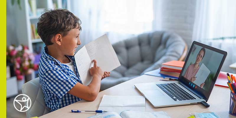 An elementary student in a blue plaid shirt works online to become a better independent learner.