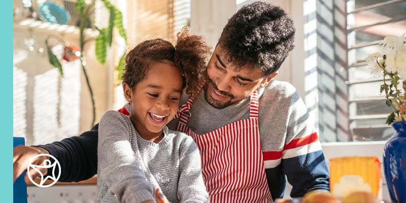 A father is helping his dauther learn how to bake