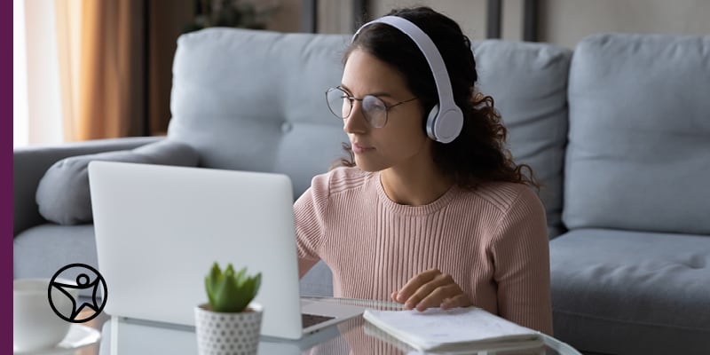 State Test Taking Tips for Students and Parents - Image of a young female student in a pink sweater taking an online test on her laptop.