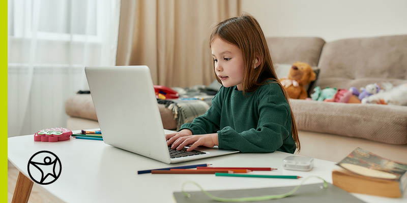 Student studying in a green sweater typing on her laptop while taking online class at Connections Academy.