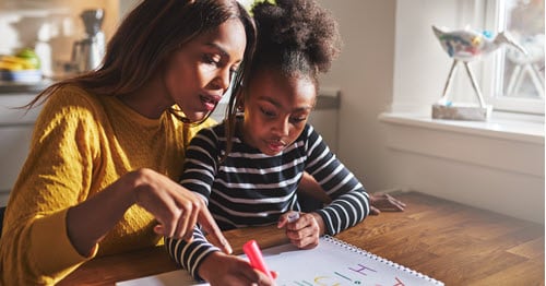 A parent helps her child with her assignment as a Learning Coach. 