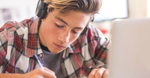 A student using motivational journal prompts to start writing.