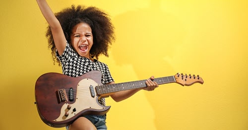A child learning to play guitar.