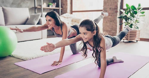 A parent and child practicing yoga.