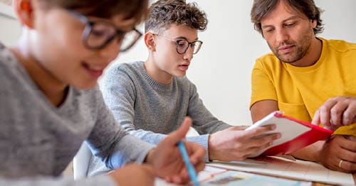 A parent and online students learning at home. 