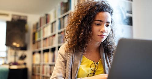 A student using a laptop to research what high school students need to do to be successful.