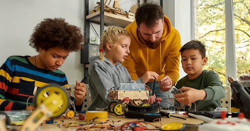 A group of students, who are learning to love learning, doing a STEM activity with their Learning Coach.