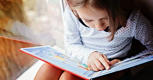 An online student reading books for children.