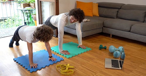 A parent teaching a child about self-care with yoga.