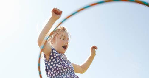 A child is outside hula hooping