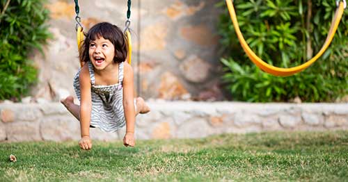 A smart child playing on a swing.
