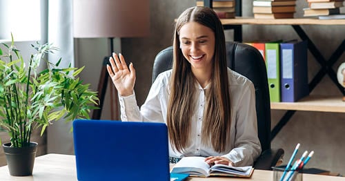 An online school teacher greeting her students at the start of her online class