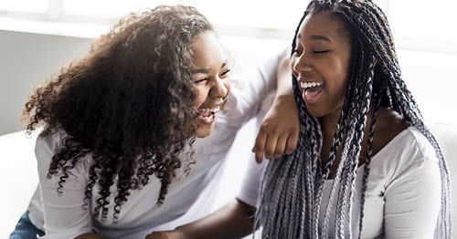 Two online students laughing.