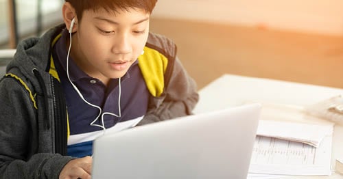 An online school student researching on a laptop.