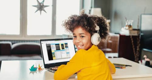 An online schol student overcoming pandemic learning loss by studying at a laptop.