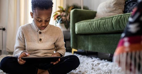 A child reading on a tablet. 