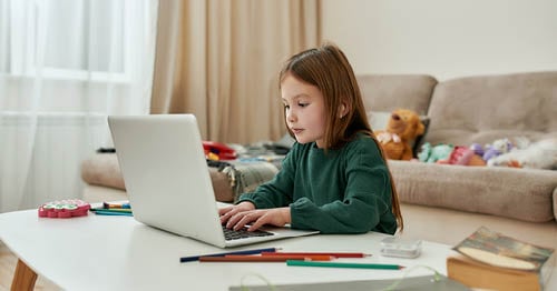 An online school student practicing home school time management skills while completing her assignments. 