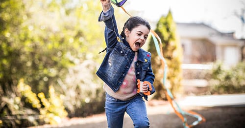 An online student playing outside to improve her positive thinking strategies.