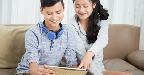 A pair of online school students find age-appropriate books in a tablet.