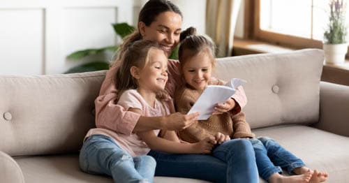 A mother reading to her young daughters.