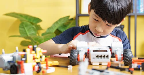 A child builds a model as part of a bodily kinesthetic activity.