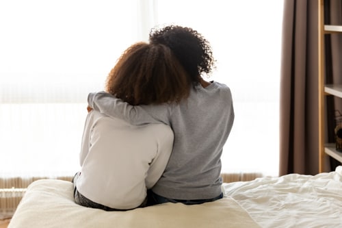 A parent consoling a bullied child. 