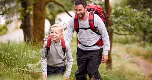 A parent being a good role model for his child go on a hike.    