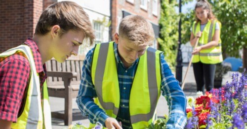 Online high school students volunteering at a community garden. 