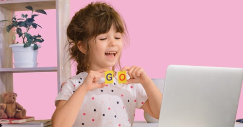 A girl practicing her alphabet in her online kindergarten class. 