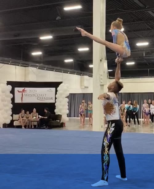 Two young people practicing an acrobatic dance routine.