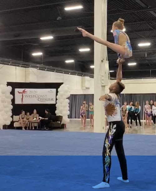 Two young people practicing an acrobatic dance routine. 