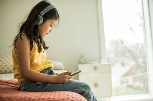 A child looking at social media on her phone.