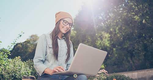 An online school student in a white shirt and yellow hat developing career skills.