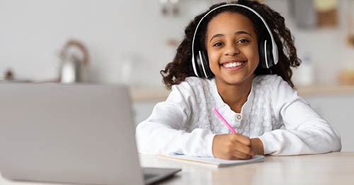 An online student smiling in a white sweater.