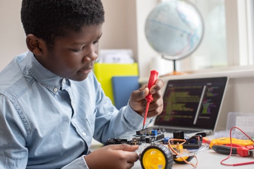 Connections Academy student works on a STEM project building a small robot which will respond to code.