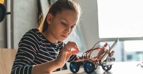 An online student works on a STEM project in her at-home learning space