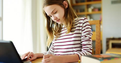 An online school student working on her laptop