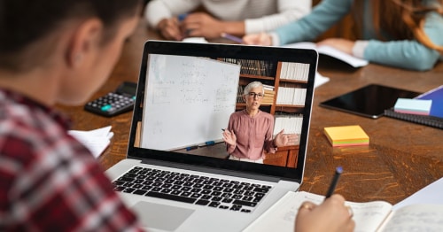 A student watching an instructor teach virtually on a laptop computer