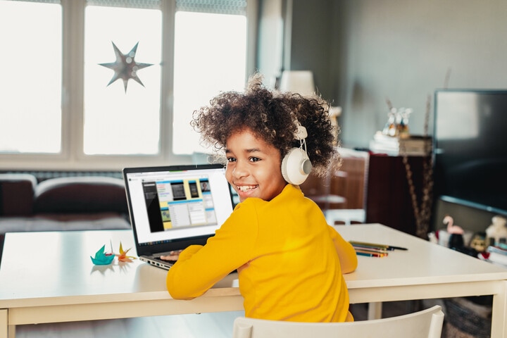 A young student is lisitening to their online elementary school lesson