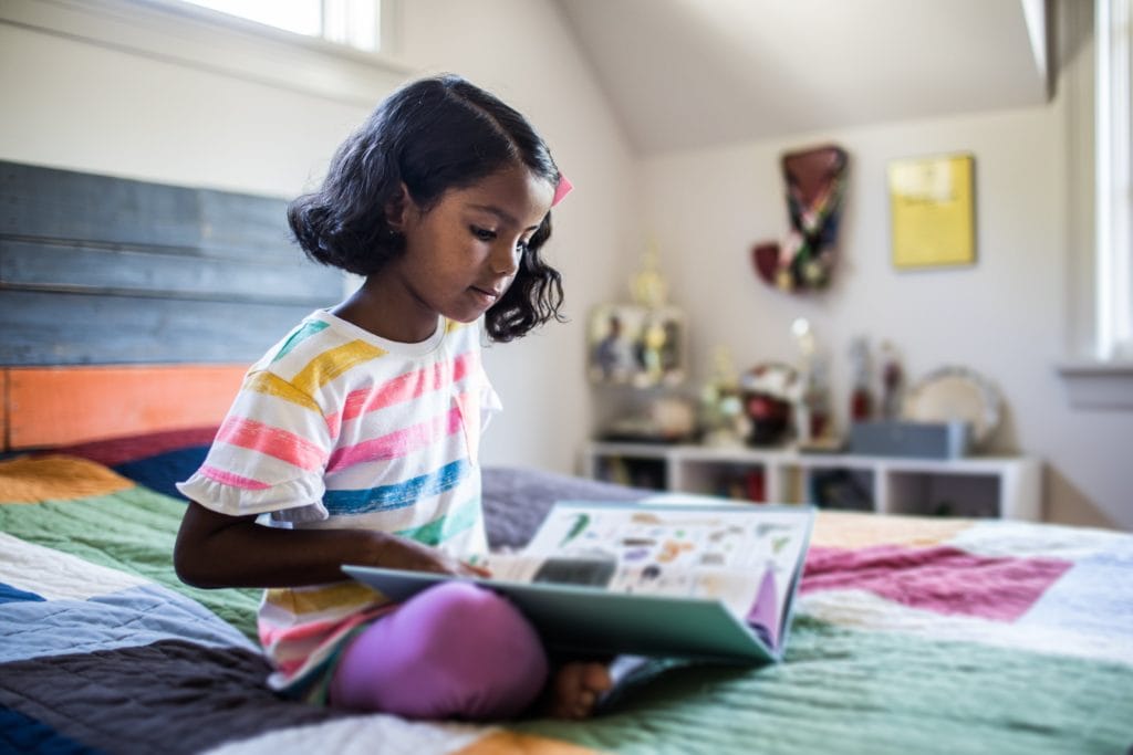 A girl studying from a book during summer break