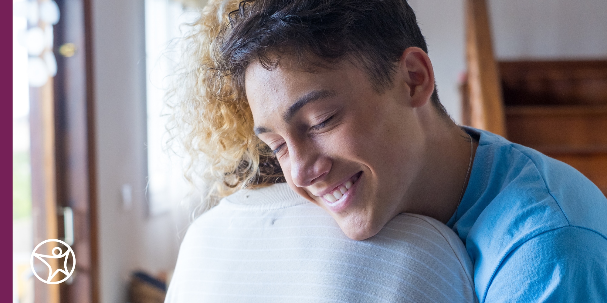 A teenager huggin his mother