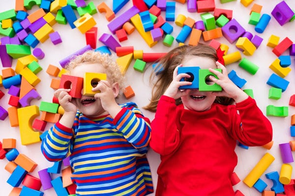 Two kids playing with colorful blocks
