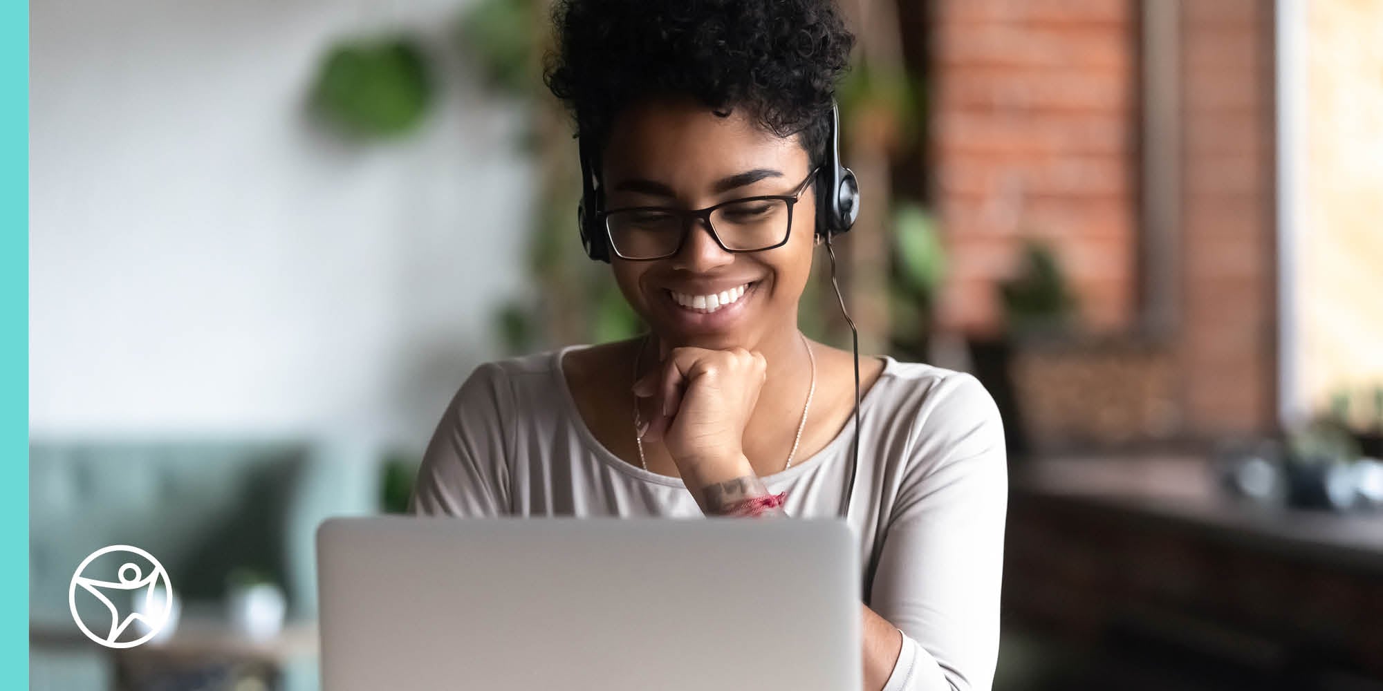 A high school students is sitting outside on laptop