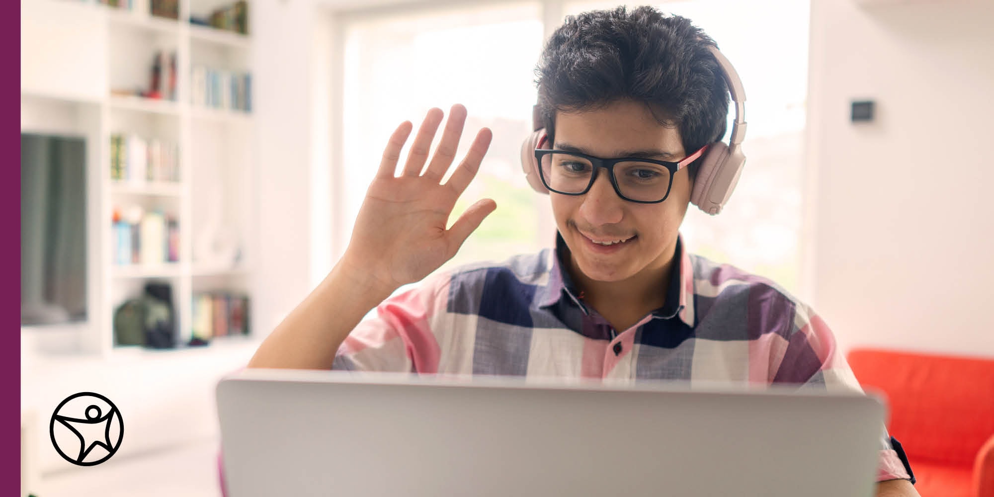 A boy is raising his hand while in online class