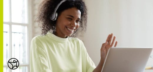 A women is waving at laptop for an online class