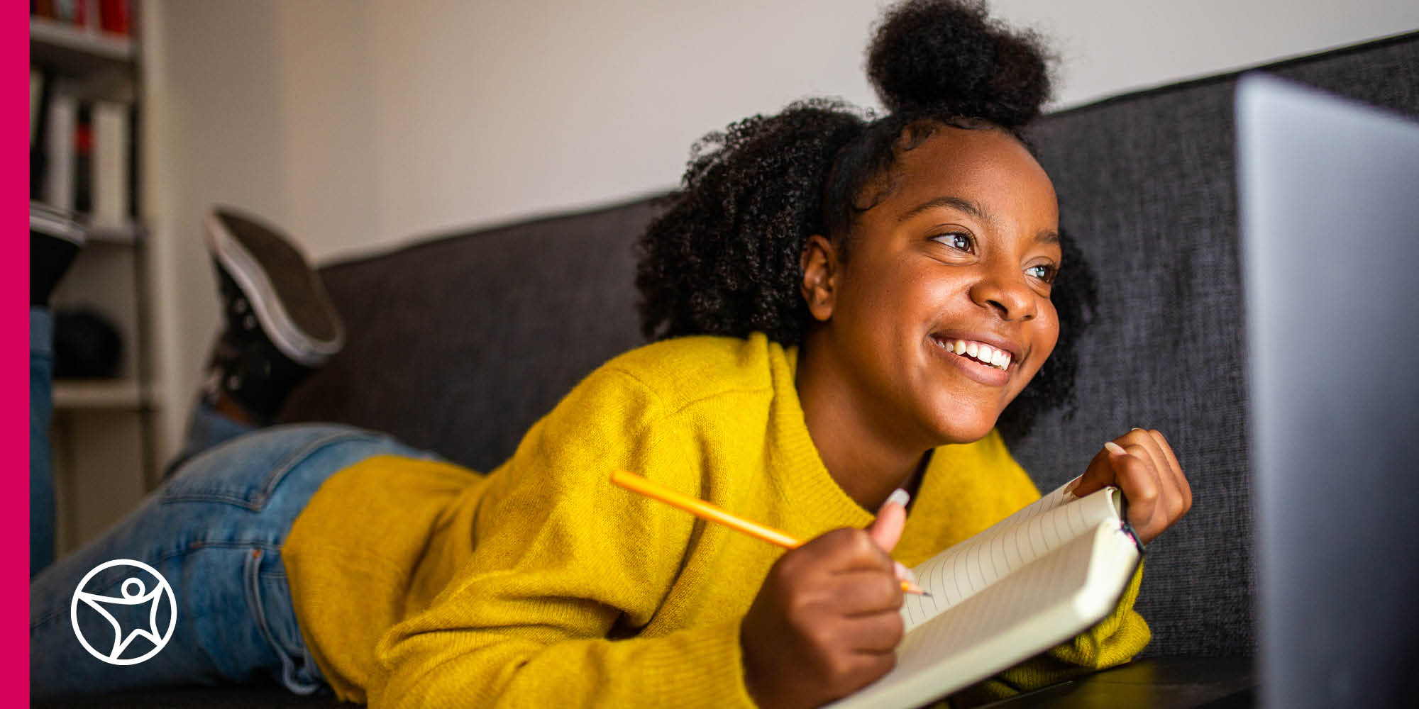 Young online student writing in a notebook