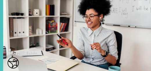 A teacher is sitting at a desk leading an online class